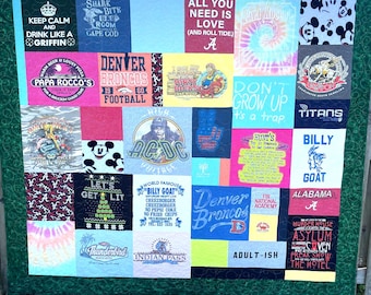 May include: A patchwork quilt constructed from various graphic t-shirts featuring diverse logos, slogans, and patterns including Denver Broncos, AC/DC, Mickey Mouse, and Alabama Crimson Tide, all bordered by a dark green fabric with a swirling pattern.