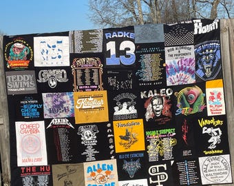 May include: A black and white quilt made from various band t-shirts. The quilt features band names like "Teddy Swims", "The Haunt", "Vandoliers", "Kingfish", "Radke 13", "The Hu", "Allen Stone", "Camo", "Coheed and Cambria", "Jack White", "Highly Suspect", "Theory of a Deadman", "Kaleo", "Rob Aldridge and the Proponents", "The Monsters", "St. Paul Broken Bones", "Troublemakers", "All Time Low", "Bayou Seale", and "Blu Eye Extinction".