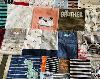 May include: A patchwork quilt made from baby clothes with various designs and colors, including blue, green, red, and white. The quilt features a variety of images, including a dinosaur, a dog, a teddy bear, and a whale. The quilt also includes the text "Little Brother", "Mommy's Little Guy", and "Best Buddies".
