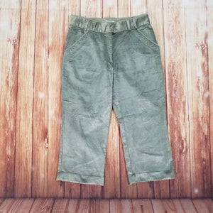 May include: A pair of green corduroy capris with a straight leg and a cuffed hem.