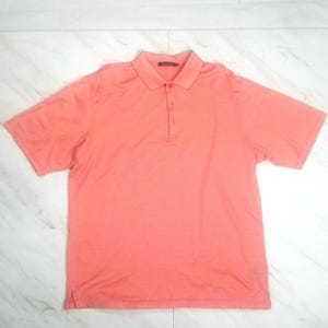 May include: A coral colored short-sleeved polo shirt with a button-up collar.