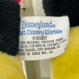May include: White tag with black text that reads "Disneyland Walt Disney World&reg; &copy;DISHEY All New Materials Polyester Fibers 1525:PA 1378:OHIO PA 1378:MASS 7-610 Masa Trading Corp. Burbank, CA, Product of Korea MFR-101"