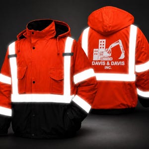 May include: A high-visibility orange and black hooded jacket featuring reflective silver stripes, a front zipper, and two chest pockets. The back displays a white graphic of an excavator and building with the text DAVIS & DAVIS INC.