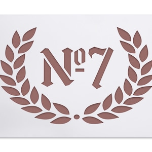 Könnte beinhalten: Eine weiße Schablone mit einem braunen Lorbeerkranz-Design und dem Text "N°7" in der Mitte.