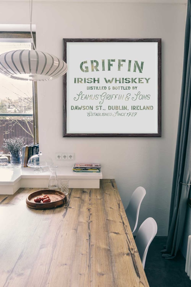 K&ouml;nnte beinhalten: Ein gerahmter Druck mit einem Vintage-Design f&uuml;r Griffin Irish Whiskey. Der Text lautet "Griffin Irish Whiskey, Destilliert und abgef&uuml;llt von Seamus Griffin & Sons, Dawson St., Dublin, Irland, Gegr&uuml;ndet seit 1787".