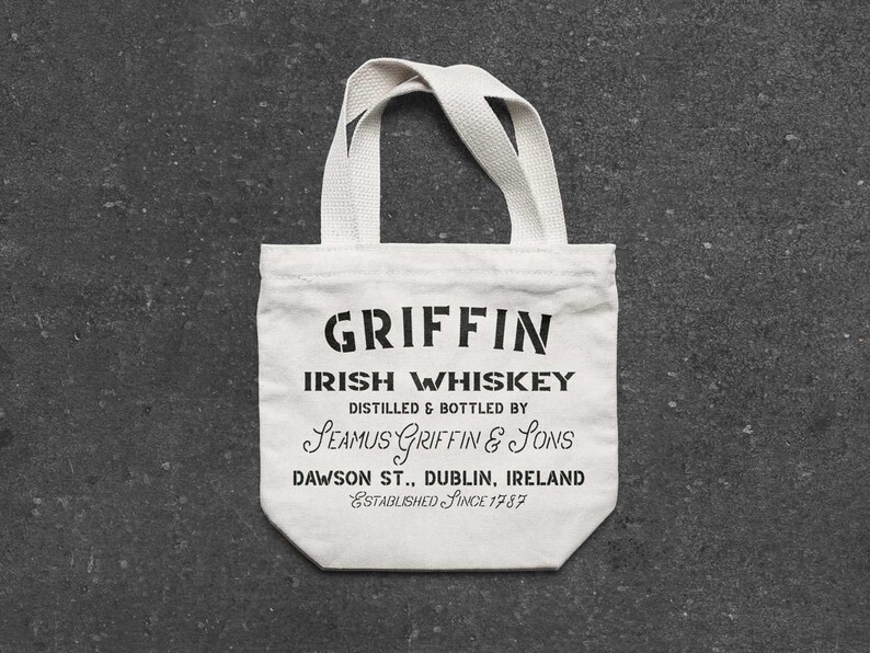K&ouml;nnte beinhalten: Wei&szlig;e Stofftasche mit schwarzem Text, der "GRIFFIN IRISH WHISKEY DISTILLED & BOTTLED BY SEAMUS GRIFFIN & SONS DAWSON ST., DUBLIN, IRELAND ESTABLISHED SINCE 1787" lautet