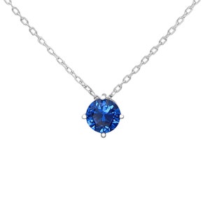 May include: A silver chain necklace with a blue gemstone pendant.