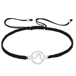 May include: A black braided bracelet with a silver wave charm. The bracelet is adjustable with a sliding knot.
