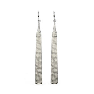 May include: A pair of long, silver earrings with a hammered texture. The earrings are simple and elegant.