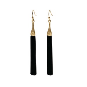 May include: A pair of long, black earrings with gold-colored tops and ear wires. The earrings have a simple, elegant design, with a rectangular black body and a textured gold-colored top. The earrings are displayed against a white background.