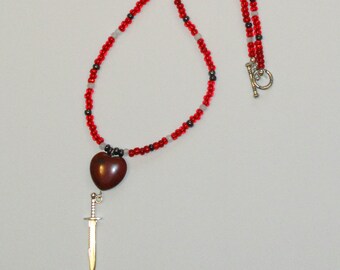 Swordheart Necklace: jasper heart and silvery sword charm on a string of red, black, and white seed beads