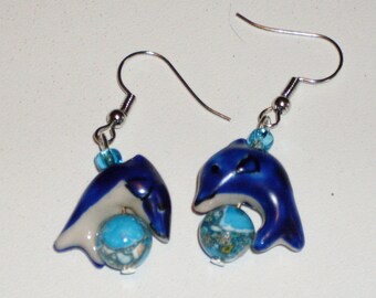Day of the Dolphin: earrings with navy blue ceramic dolphins leaping over blue marble