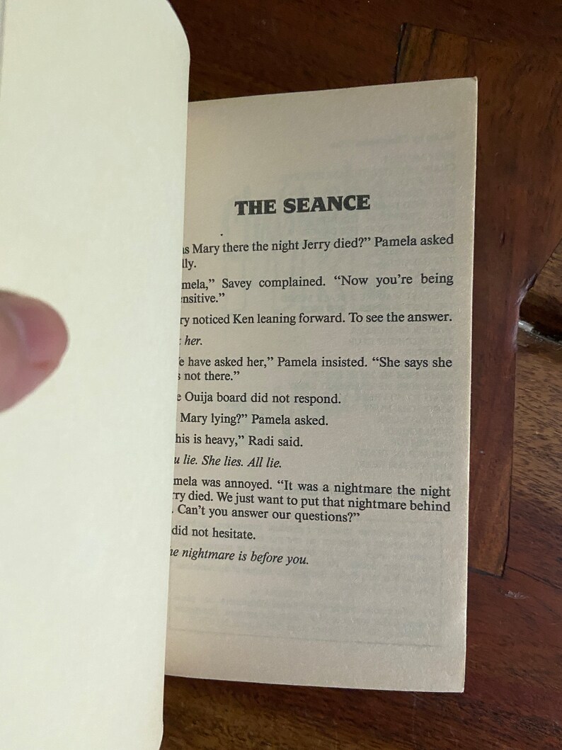 Może przedstawiać: Zbliżenie na stronę książki z tytułem "The Seance" i tekstem o tablicy Ouija i koszmarze. Tekst jest w czerni i bieli.