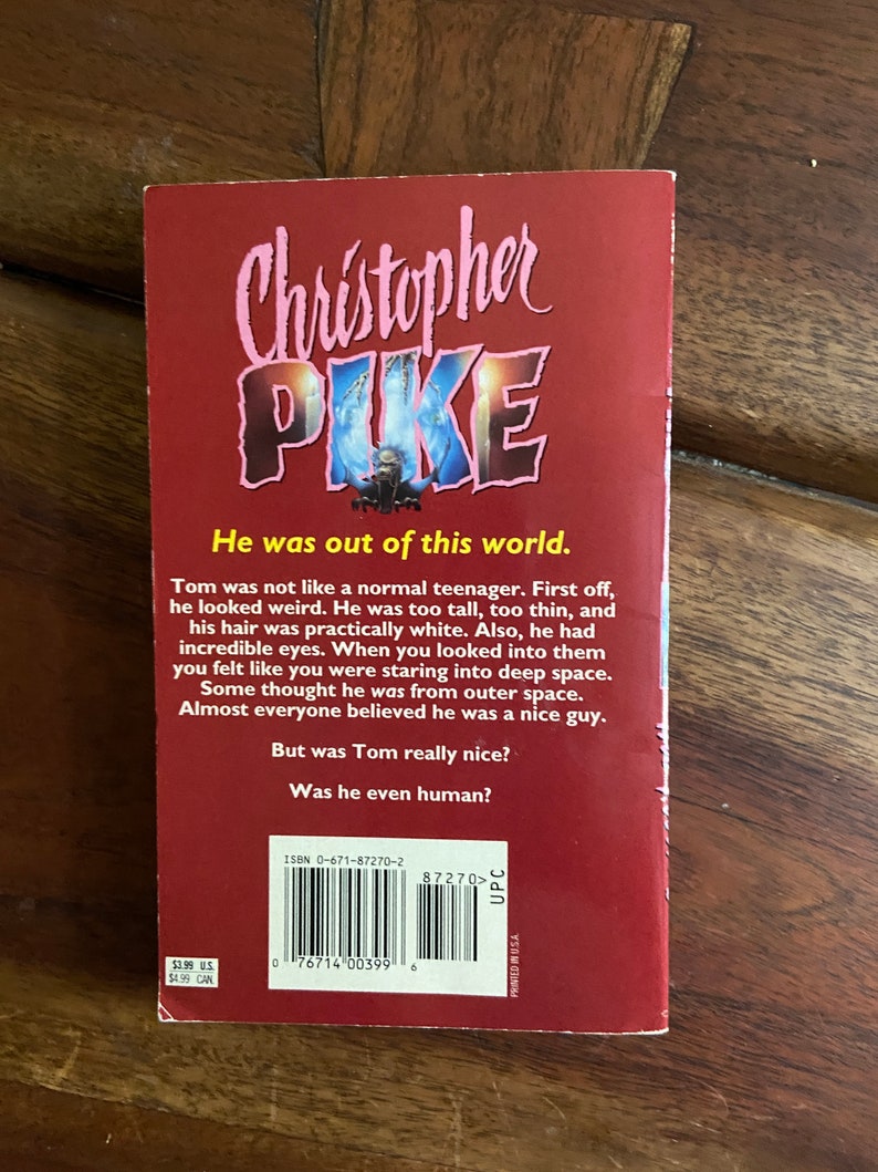 Może przedstawiać: Czerwona książka w miękkiej oprawie z tytułem "Christopher Pike" w r&oacute;żowych literach. Okładka książki przedstawia czarno-białą ilustrację osoby o przerażającym wyrazie twarzy. Tekst na tylnej stronie książki brzmi: "Był poza tym światem." i "Tom nie był jak normalny nastolatek. Po pierwsze, wyglądał dziwnie. Był za wysoki, za chudy i jego włosy były prawie białe. Poza tym miał niesamowite oczy. Kiedy patrzyłeś w nie, czułeś się, jakbyś wpatrywał się w głęboką przestrzeń kosmiczną. Niekt&oacute;rzy myśleli, że pochodzi z kosmosu. Prawie wszyscy wierzyli, że jest miłym chłopakiem. Ale czy Tom był naprawdę miły? Czy był w og&oacute;le człowiekiem?" Numer ISBN to 0-671-87270-2.