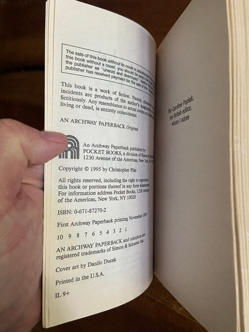 Może przedstawiać: Zbliżenie na informacje o prawach autorskich i publikacji książki w miękkiej oprawie. Tekst zawiera tytuł "An Archway Paperback Original", wydawnictwo "Pocket Books", rok praw autorskich "1995", autora "Christophera Pike'a", ISBN "0-671-87270-2" oraz datę wydania "listopad 1995".
