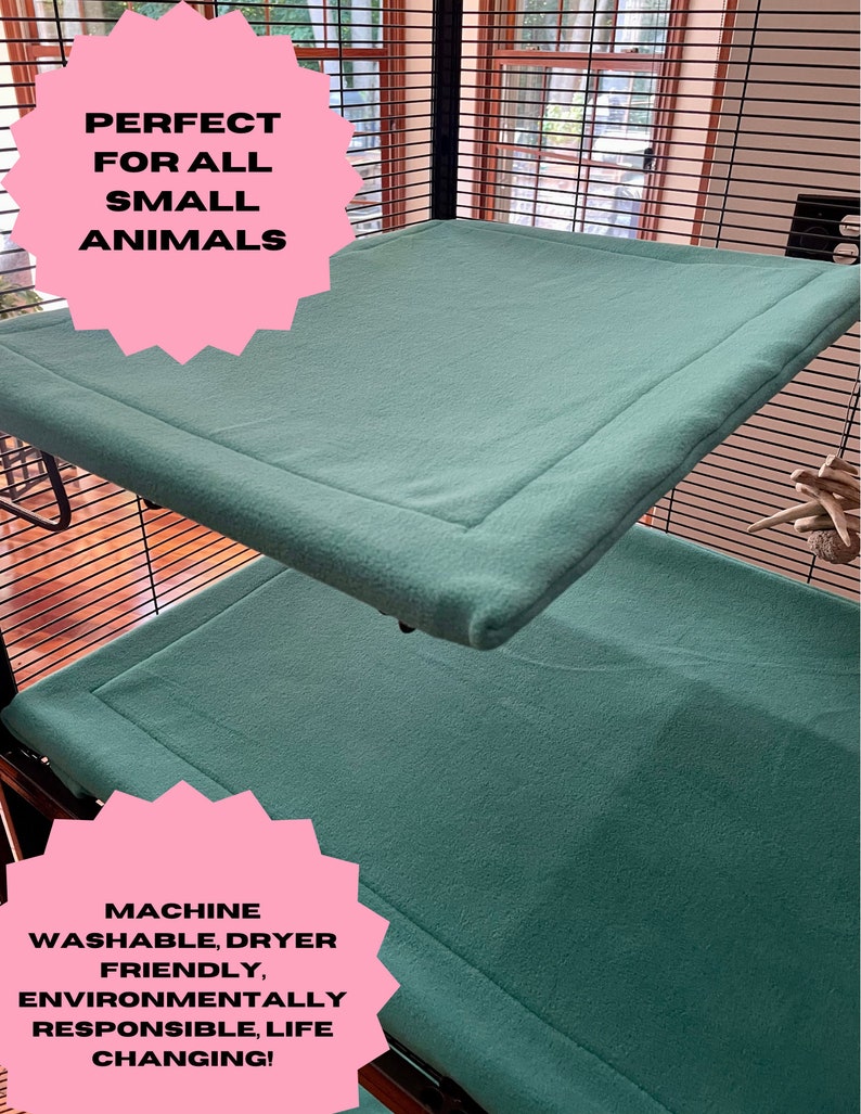 May include: Two teal fleece-lined platforms for small animal cages. The platforms are machine washable and dryer friendly. The text "PERFECT FOR ALL SMALL ANIMALS" and "MACHINE WASHABLE, DRYER FRIENDLY, ENVIRONMENTALLY RESPONSIBLE, LIFE CHANGING!" is visible in pink.