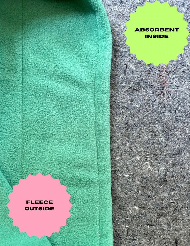 May include: A close-up of a green fleece fabric with the text "FLEECE OUTSIDE" on a pink starburst sticker. The fabric is sewn to a gray fabric with the text "ABSORBENT INSIDE" on a green starburst sticker.