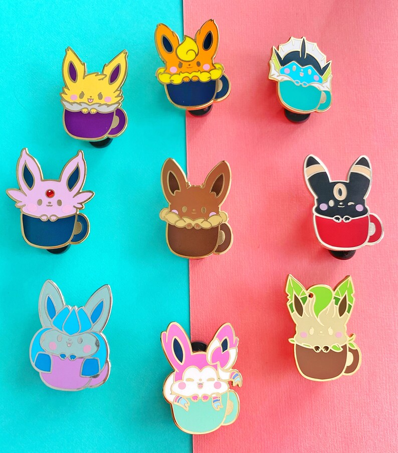 May include: Nine enamel pins featuring different Pokemon characters in various colors, each holding a cup of coffee or tea. The pins are arranged in two rows on a blue and pink background.