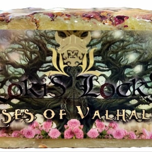 May include: A rectangular bar of soap with the text "Loki's Locks Roses of Valhalla". The soap has a light green base with embedded rose petals. The label features a tree design and pink roses.
