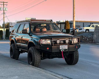 May include: A black Toyota 4Runner SUV with a roof rack, a front bumper with a winch, and a license plate that reads "LN3-61T".