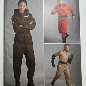 Könnte beinhalten: Simplicity Schnittmuster 8722 zeigt einen Overall mit Kapuze, Taschen und Gürtel. Das Schnittmuster enthält verschiedene Ansichten des Overalls in verschiedenen Farben. Entworfen und gedruckt in den USA, Größen XS-XL.