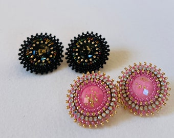May include: A pair of earrings, one with black beads and a black center, and the other with pink beads and a pink center.