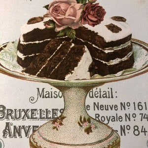 May include: A multi-layered chocolate cake with white frosting and a decorative arrangement of pink roses on top. The cake is on a white cake stand with a gold trim. The text "Maison Cl&eacute;ment" is visible at the top of the image.