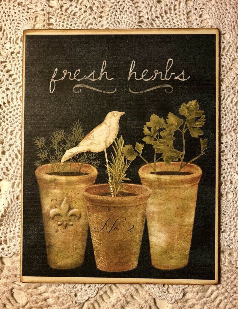May include: A black chalkboard sign with the text "fresh herbs" in white script. Three terracotta pots with different herbs are depicted, with a white bird perched on a branch in the center pot. The pots are labeled with numbers.