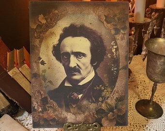 Puede incluir: Una impresión de estilo vintage de un hombre con cabello oscuro y bigote. La impresión está enmarcada con un borde decorativo y tiene un aspecto descolorido y antiguo. El fondo es de color marrón oscuro con un diseño floral.