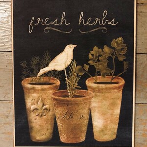 May include: A black chalkboard sign with the text "fresh herbs" in white script. Three terracotta pots with different herbs are arranged in a row. A white bird sits on a branch in the center pot. The pots are labeled with a fleur-de-lis and the number "2".