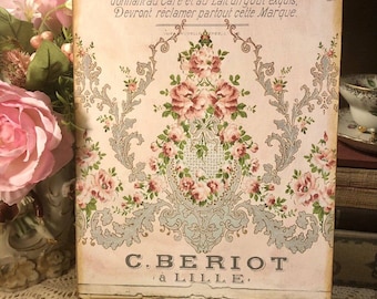 May include: A vintage-style print with a floral design in shades of pink and blue. The print features a decorative border and the text "à LILLE" and "C.BERIOT à LILLE".