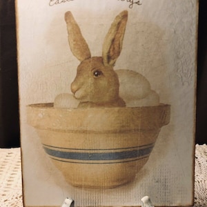 Placa / letrero artesanal primitivo con forma de conejito con bendiciones de Pascua en cuenco de cerámica amarilla