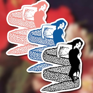 Op de afbeelding: Drie zeemeermin stickers in koraal, blauw en zwart. Elke zeemeermin heeft lang haar en een gevlekte staart. De koraal zeemeermin heeft een roze staart, de blauwe zeemeermin heeft een blauwe staart en de zwarte zeemeermin heeft een zwart-witte staart.