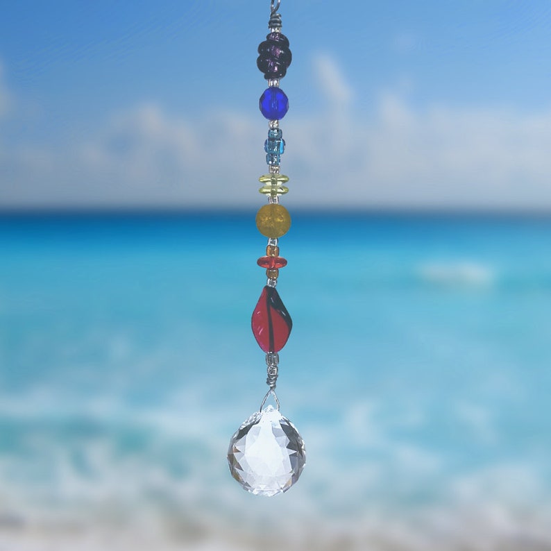 May include: A crystal suncatcher with a clear crystal ball and a beaded chain with rainbow colored beads.