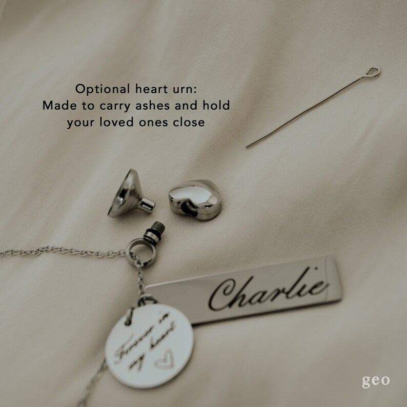 May include: Silver heart urn necklace with a small funnel and a screw top. The necklace has a tag that says "Forever in my heart" and a larger tag that says "Charlie".