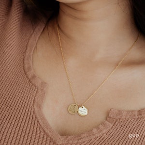 May include: A gold chain necklace with two round pendants. One pendant features a state outline and the other pendant has the text "You are my sunshine, my only sunshine, you make me happy when skies are gray".