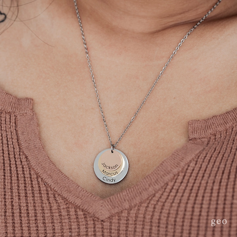 May include: A silver chain necklace with a layered pendant featuring three circular discs. The discs are engraved with the names "Jackson", "Marcus", and "Cindy".
