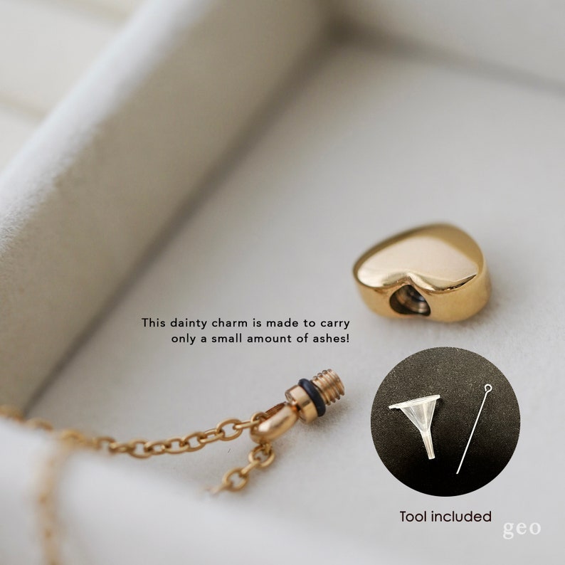 May include: Gold heart-shaped cremation charm necklace with a small funnel and a tool for filling the charm with ashes. "This dainty charm is made to carry only a small amount of ashes!" and "Tool included geo" are written on the image.