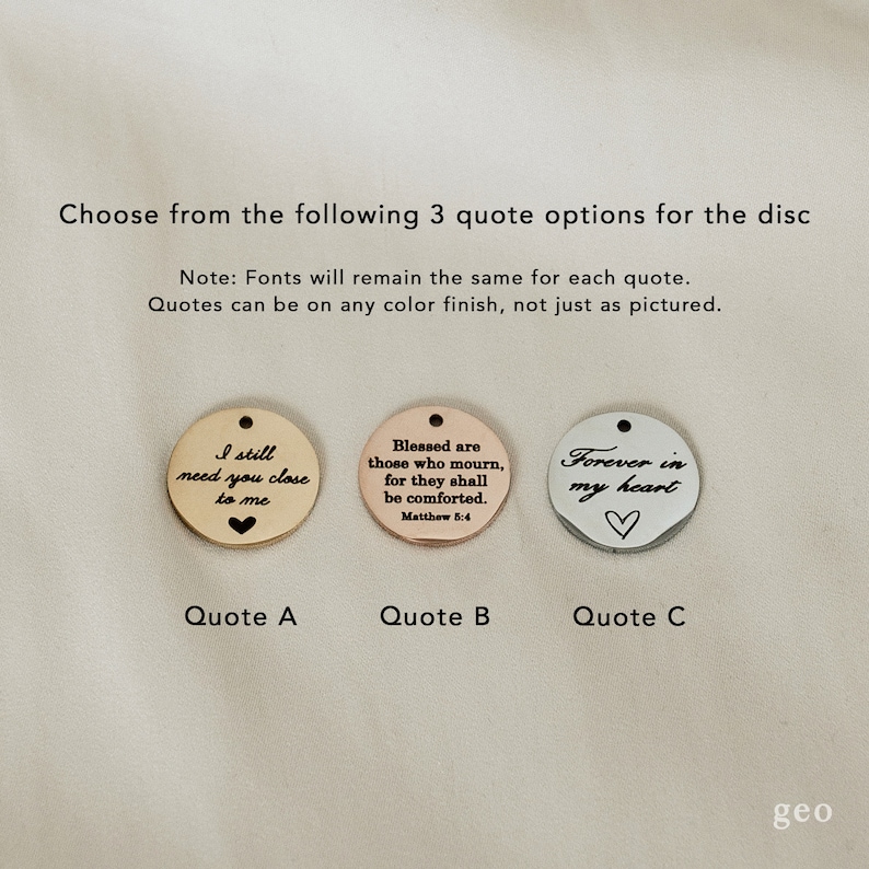 May include: Three round metal discs with different quotes engraved on them. The first disc is rose gold and says "I still need you close to me". The second disc is copper and says "Blessed are those who mourn, for they shall be comforted. Matthew 5:4". The third disc is silver and says "Forever in my heart".