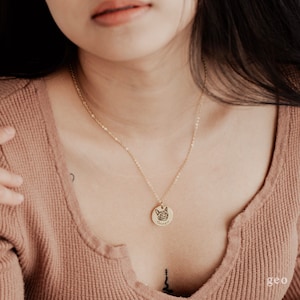 May include: A gold chain necklace with a round pendant featuring a dog's face and the name "George" engraved on it.