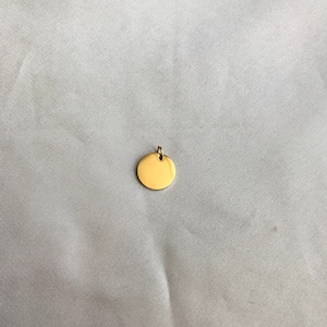 May include: A gold-colored round pendant with a smooth surface and a small loop at the top.