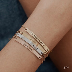 May include: Four gold, silver, and rose gold bar bracelets with engraved text. The bracelets feature the text "XII. XXXI. MMXIX", "forevermore", "LLVIIX", and "just in time".