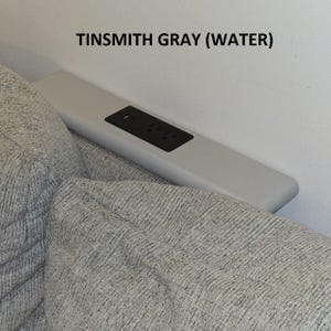 Könnte beinhalten: Nahaufnahme einer grauen Steckdose mit dem Text "TINSMITH GRAY (WATER)" darüber.