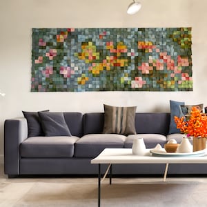 Könnte beinhalten: Ein graues Sofa mit Kissen steht vor einer Wand mit einem großen Wandbild aus Holz, das ein farbenfrohes Blumenmuster zeigt. Ein Couchtisch mit einer Vase mit orangefarbenen Blumen steht vor dem Sofa.