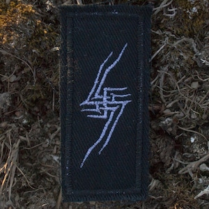 May include: A black rectangular patch featuring a white lightning bolt design. The patch is made of woven fabric, designed to be sewn or ironed onto clothing or accessories. The white design is a stylized lightning bolt, centered on the patch.