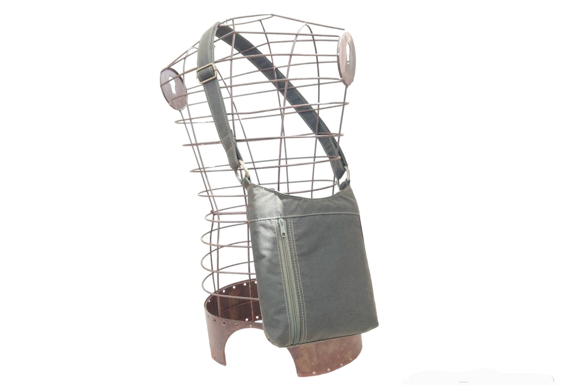 Dark khaki waxed cotton cross body bag. Long adjustable strap with zip closure. Water resistant, hard-wearing, vegan.