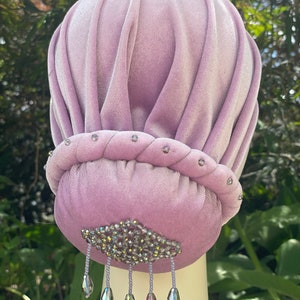 May include: A mauve velvet bun cover with a crystal embellishment and dangling crystal beads.