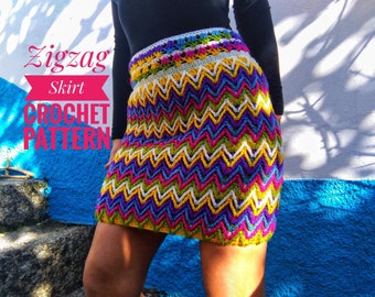 May include: A colorful crochet skirt with a zigzag pattern. The skirt is made with a variety of colors, including green, yellow, purple, pink, and white. The skirt is shown on a person standing in front of a blue and white wall. The text "Zigzag Skirt Crochet Pattern" is visible in the image.