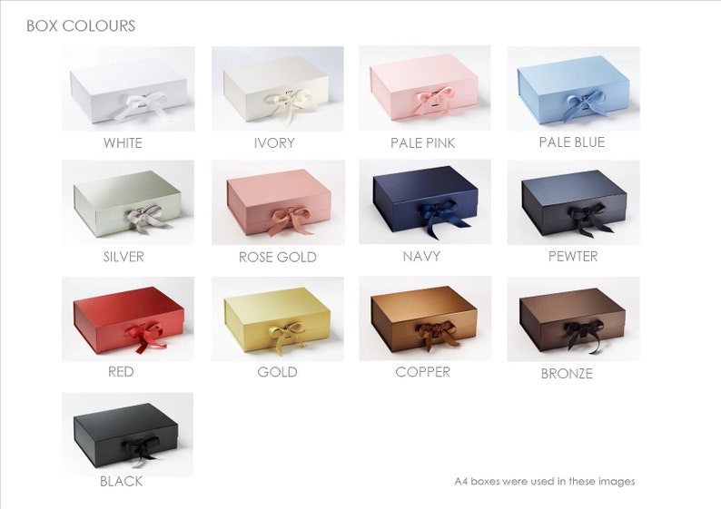 May include: A collection of thirteen rectangular gift boxes with hinged lids and ribbon closures, displayed in various colors including white, ivory, pink, blue, silver, rose gold, navy, pewter, red, gold, copper, bronze, and black.