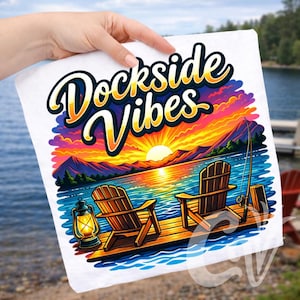 Puede incluir: Camiseta blanca con un diseño de escena de lago. Presenta dos sillas de madera en un muelle, una caña de pescar y una puesta de sol. El texto "Dockside Vibes" está encima de la escena. Una linterna está en el muelle.